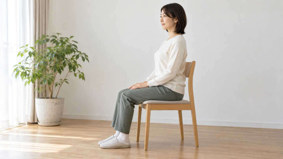 足を床につけて椅子に座る女性の説明用イメージ