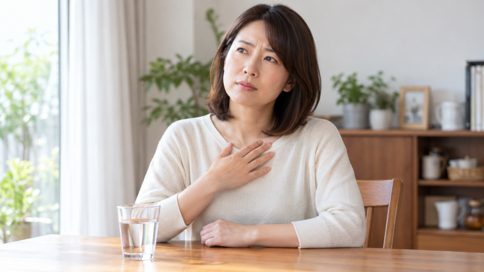 喉の違和感を気にして上胸部に軽く手を添える女性の説明用イメージ