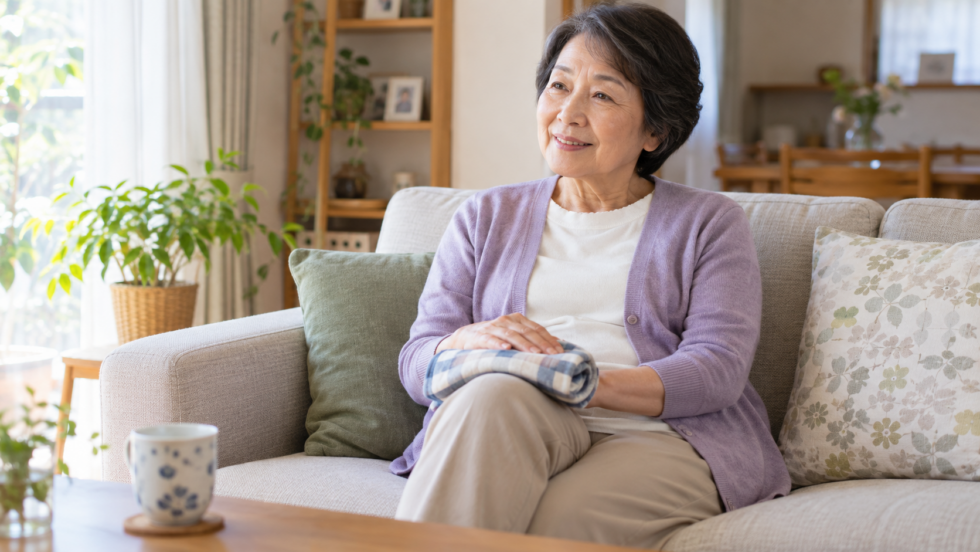 布で包んだ温熱用品を衣服の上から膝に載せる女性の説明用イメージ